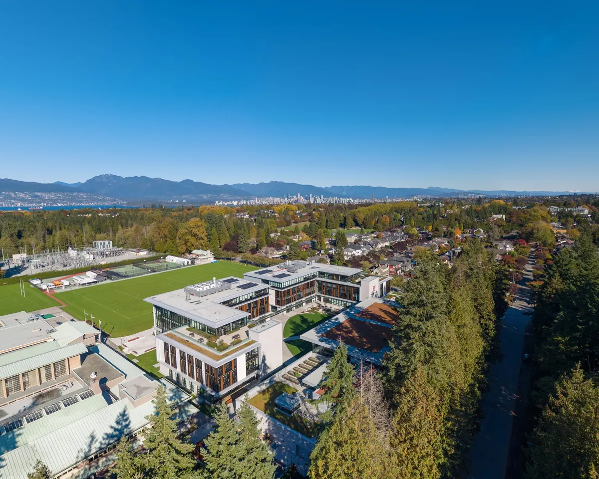 From the air, downtown Vancouver and the North Shore mountains rise in the distance beyond the new senior school and its playing field.