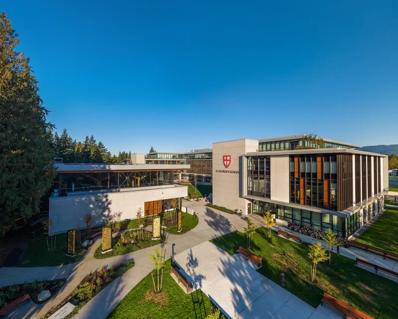 From the air, lawns and paths fill a courtyard between the new senior school buildings, and the school crest hangs on a white wall.